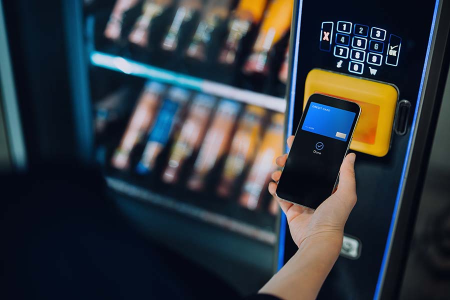 close-up-of-womans-hand-paying-for-the-product-at-vending-machine-with-contactless-payment-using-digital-wallet-on-smartphone-credit-card-payment-e-commerce-tap-to-pay